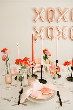 the table is set with candles, plates and napkins for an elegant valentine's day dinner