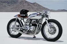 a motorcycle is parked in the desert with mountains in the background