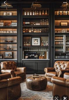 a living room filled with brown leather furniture and lots of bottles on the wall behind it