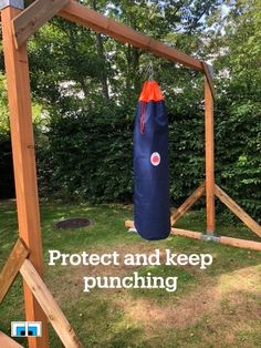 a blue bag hanging from the side of a wooden structure with words protect and keep punching