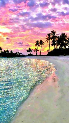 an ocean beach with palm trees in the background and colorful skies above it at sunset