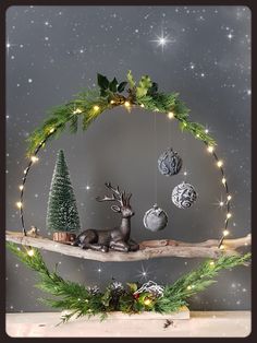 a wooden shelf with christmas decorations on top of it and lights hanging from the branches