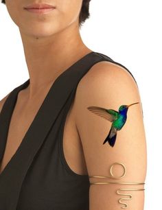 a woman with a tattoo on her arm that has a hummingbird painted on it