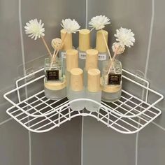 there are many bottles with flowers in them on the shelf next to the shower door