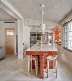 a kitchen with an island and two stools