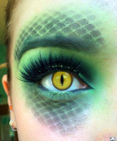 a woman with green and yellow makeup has her eyes painted like an eyeballe