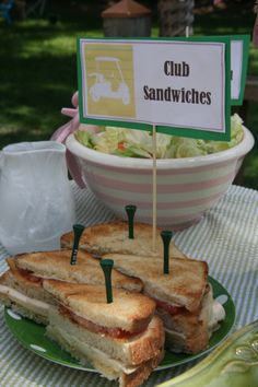 a sandwich cut in half sitting on top of a green plate next to a bowl of salad