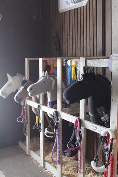 several horse heads mounted to the side of a stable