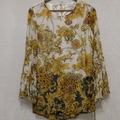 New Nygard Women's Missy Gold Baroque Blouse With Pleated Bell Sleeves - Pleated Sleeves And Ornate, Elegant Patterning - Sheer, Light, Airy And Free-Flowing For Comfort - Silky Polyester Bodice Lining - Easy To Operate, Flexible Nylon Cording - Button Closure - Size Small Spring Baroque Print Long Sleeve Tops, Elegant Long Sleeve Blouse With Baroque Print, Elegant Long Sleeve Baroque Print Blouse, Elegant Baroque Print Tops For Spring, Elegant Baroque Print Tops For Summer, Elegant Baroque Print Summer Tops, Gold Baroque, Gold Blouse, Pleated Sleeves