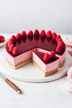 a cheesecake with raspberries is on a plate