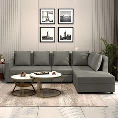 a living room with grey couches and pictures on the wall above them, along with a coffee table