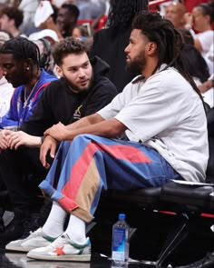 two men sitting next to each other at a basketball game