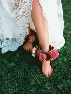 the bride's barefoot shoes are adorned with flowers