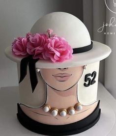 a white hat with pink flowers on top and number 52 on the side, sitting on a table