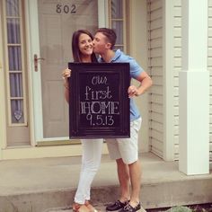 a man and woman standing on steps holding a sign