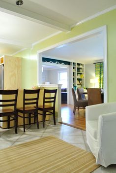 a dining room table and chairs are in the middle of a living room with yellow walls