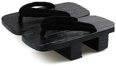 two pairs of black sandals sitting on top of each other