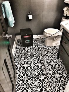 a bathroom with black and white tiles on the floor