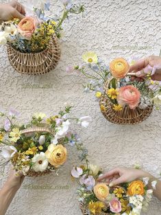 four baskets filled with flowers on top of a white wall next to two hands reaching for each other