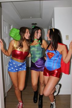 three women dressed up as superheros are posing for the camera in an open doorway