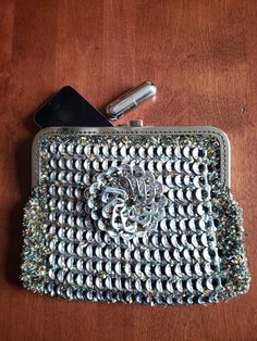 a silver purse sitting on top of a wooden table