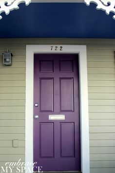 a purple front door with white trim on a house