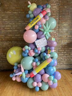 a bunch of balloons are stacked on top of each other in the shape of a christmas tree