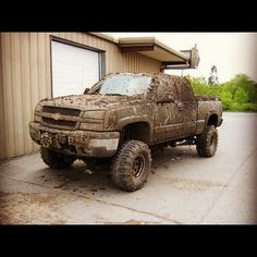 a dirty truck parked in front of a garage