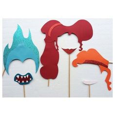 three different types of masks on sticks with one being a shark and the other is a mermaid