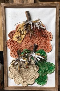 a wooden frame with four pieces of doily in it