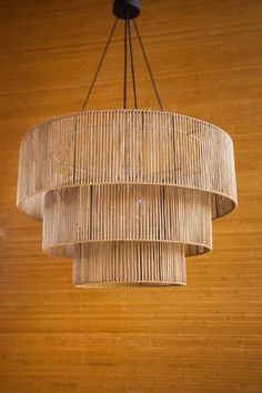 a chandelier made out of bamboo sticks hanging from a wooden ceiling in a room