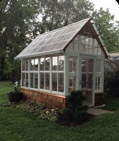 a small house with lots of windows in the yard