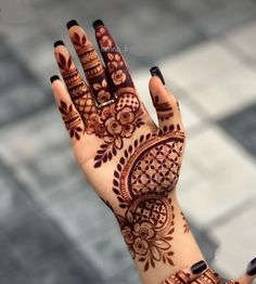 a woman's hand with henna tattoos on it