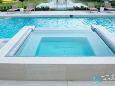 an empty swimming pool with lounge chairs around it