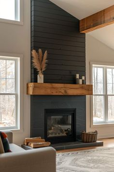 a living room filled with furniture and a fire place in front of a fireplace covered in black painted wood