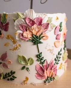 a close up of a cake with flowers on it's frosting and icing