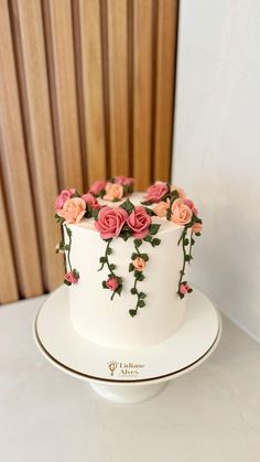 a white cake with pink roses on it