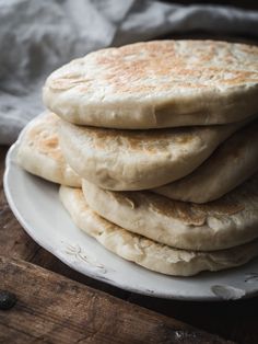 a stack of pita bread sitting on top of a white plate