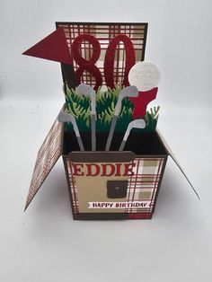 an open box with some paper flowers in it and the word weddle on top