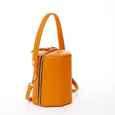 The cute Harper unexpected geometric shape gives this orange leather crossbody bag a playful but sophisticated runway savvy look. With its gold hardware, its small handle allows this orange leather bucket bag to swivel and be held in hand as a bucket. Its top zipper will keep your contents secure inside, while the cotton lined interior with 3 compartments keeps everything organized. This trendy designer crossover barrel bucket purse comes with a long and comfortable leather strap that can be flu Orange Leather Shoulder Bag With Zipper Closure, Orange Crossbody Shoulder Bag With Gold-tone Hardware, Shopping Bucket Bag With Zipper Closure, Modern Bucket Bag With Zipper Closure, Orange Bucket Bag With Removable Pouch For Shopping, Orange Crossbody Bucket Bag, Modern Orange Crossbody Shoulder Bag, Orange Shoulder Bag With Detachable Handle For Office, Orange Office Shoulder Bag With Detachable Handle