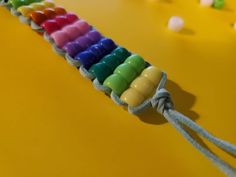 a row of colorful candles sitting on top of a yellow table next to gummy bears