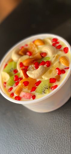 a white bowl filled with fruit on top of a table