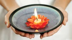 a person holding a plate with a candle in it