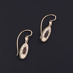 Add a touch of intrigue to any ensemble with these unique insect earrings! To create these earrings, our jeweler carefully cut antique shibayama game pieces (circa 1880) into an oval shape, mounted them in 14k gold, and added 14k ear wires and sapphire surmounts. Each earring measures 1 inch from the top of the ear wire to bottom by 0.3 inches wide, and they are in excellent condition. Materials: Sapphire, Gold. Victorian Oval Pierced Earrings, Victorian Jewelry With Oval Matching Earrings, Antique Brass Oval Earrings, Antique Oval Brass Earrings, Heirloom 14k Gold Oval Earrings, Heirloom Oval 14k Gold Earrings, Antique Oval Earrings, Victorian Oval Brass Earrings, Oval Brass Earrings For Formal Occasions