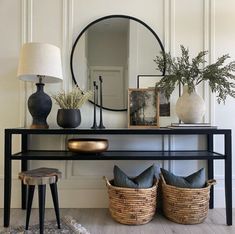 a black console table with baskets and lamps