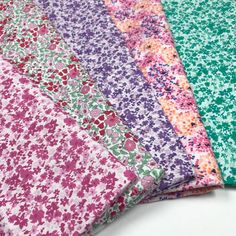 four different colors of fabric on top of each other with flowers and leaves in them