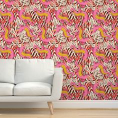 a white couch sitting next to a wall with pink flamingos on it