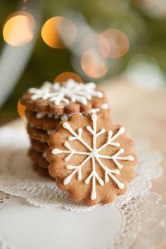 some cookies are sitting on a doily with snowflakes in the middle and white frosting