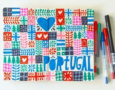 a notebook with the words portugal written on it and two markers next to it,