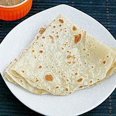 two tortillas on a plate next to a bowl of salsa